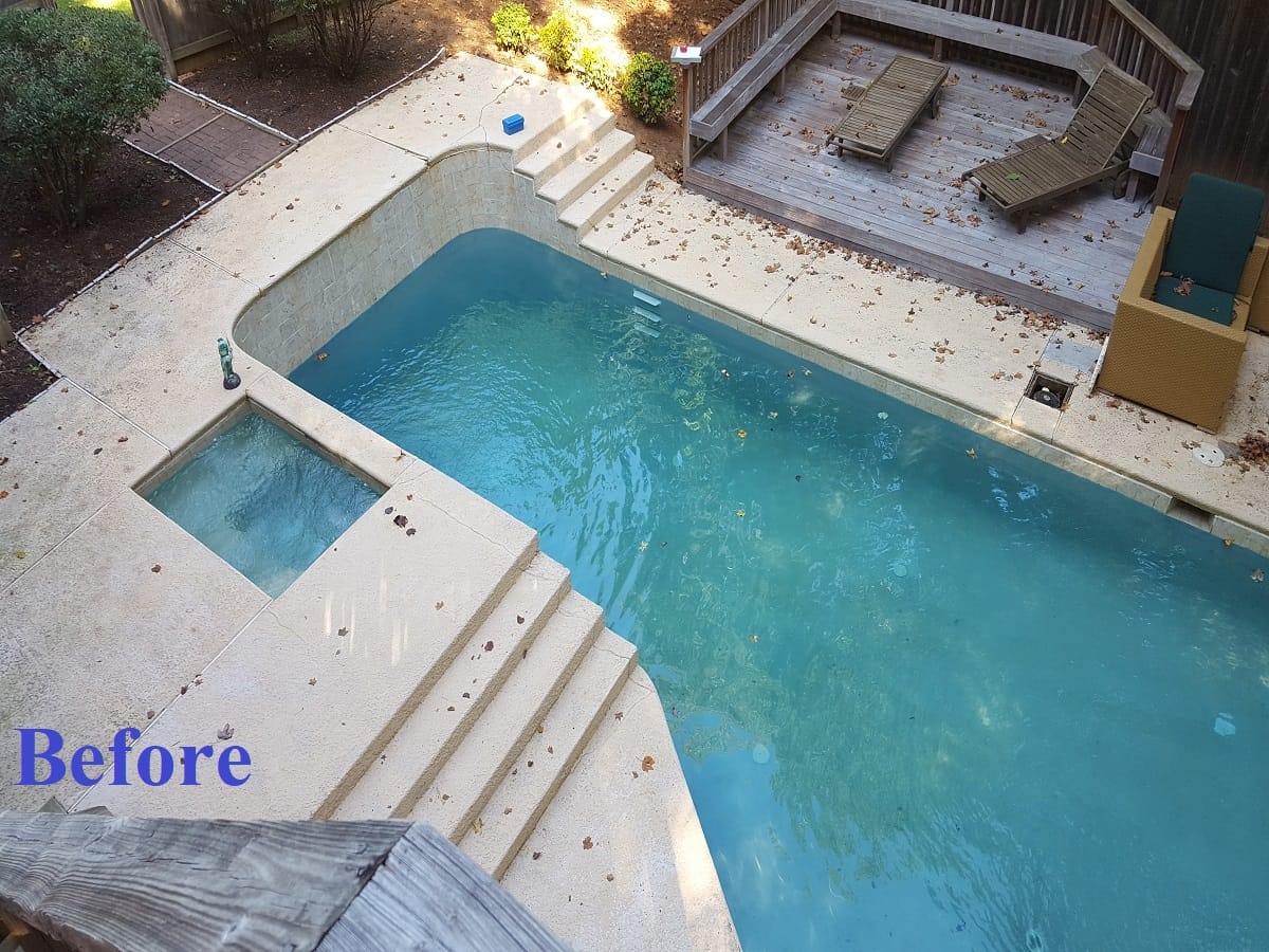 Open inground pool with steps and attached spa before the safety cover
